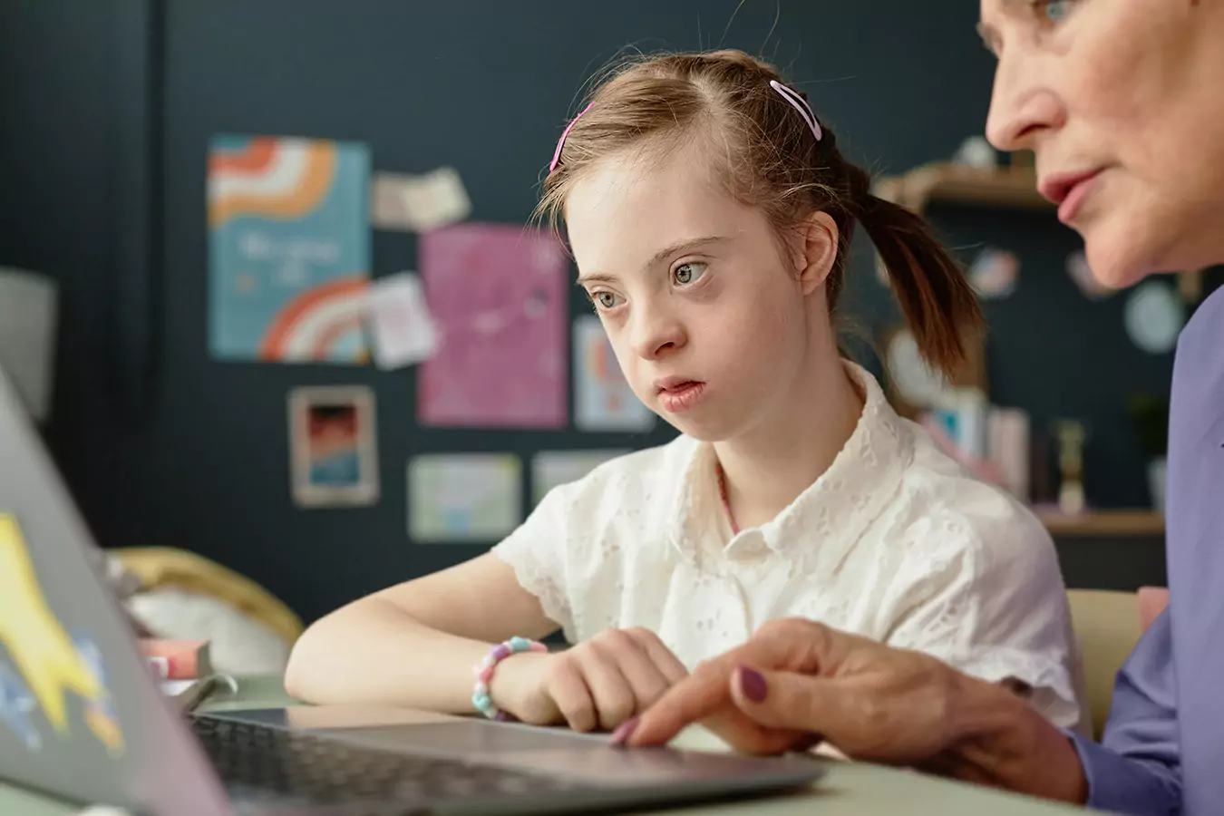 A disabled woman reading with her teacher